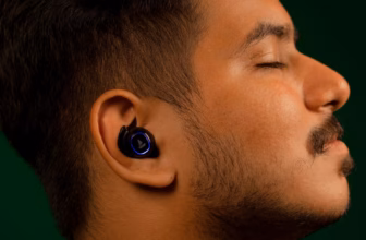 Mann hört mit geschlossenen Augen entspannt Musik über In-Ear-Kopfhörer