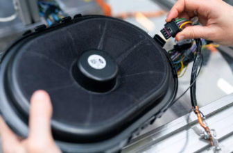 Techniker prüft im Werkstattlabor den Aufbau eines Lautsprechers und die Verkabelung an Verstärker und Anschlüsse