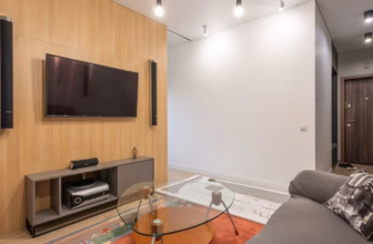 Modernes Wohnzimmer mit Sofa und an der Wand montierten Lautsprechern für Heimkino-Sound