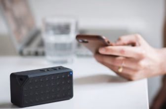 Person verbindet ihr Smartphone mit einem tragbaren Lautsprecher